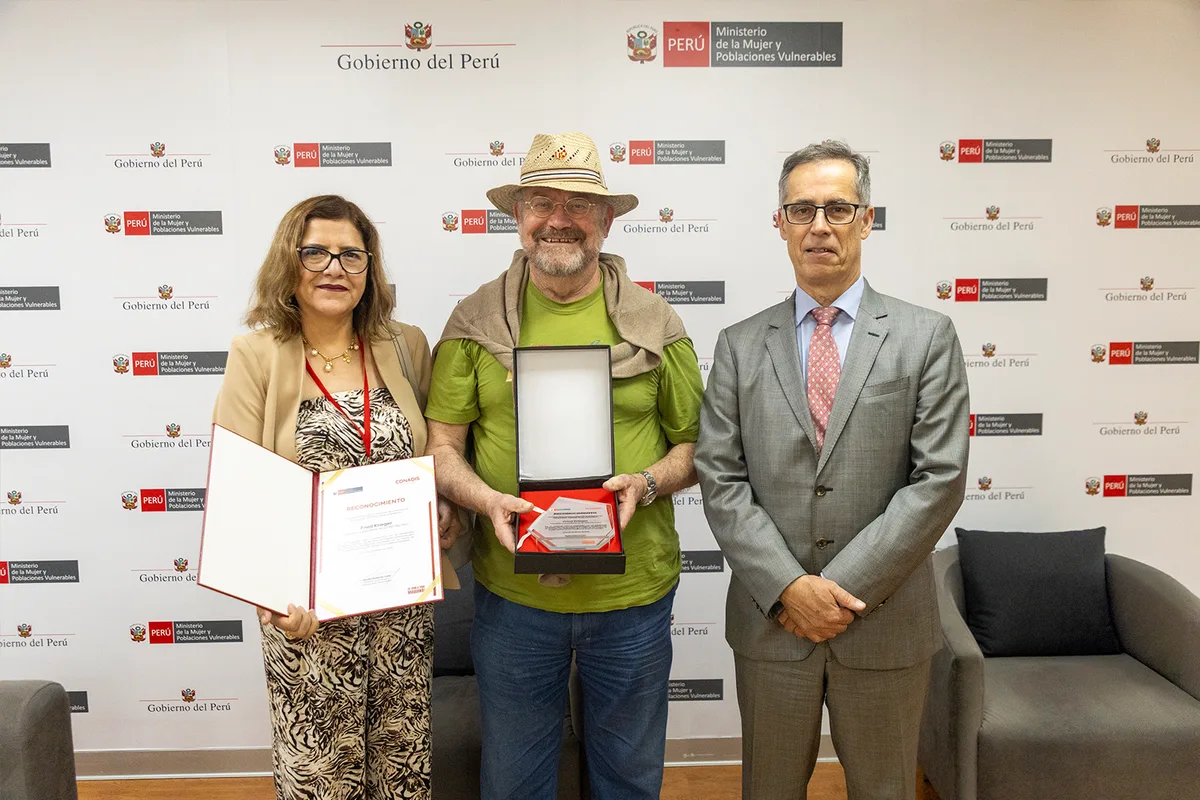 Drei Personen bei Urkundenübergabe